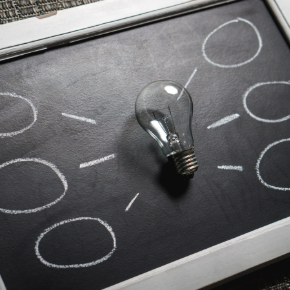 Lightbulb on a mini blackboard with clack lines and bubbles (indicating thoughts)